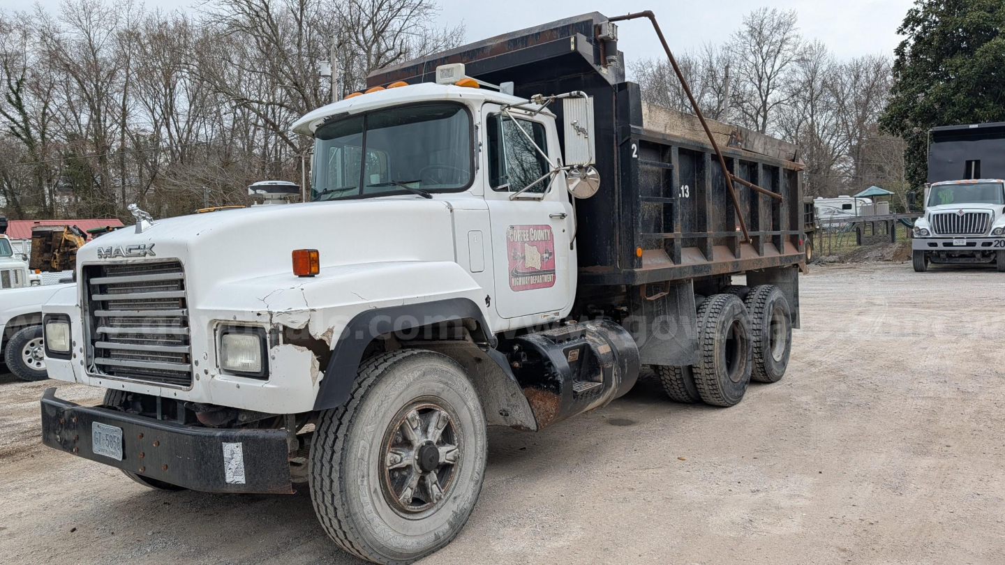 Dump truck from side showing Mack RD690S with dump bed and white cab.
