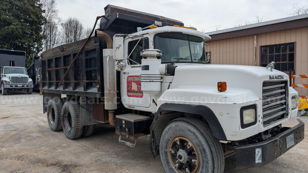 Dump truck 2000 Mack RD690S in-service showing front grille, cab, and dump bed with side panels and chained tailgate.