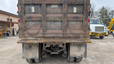 Dump truck rear showing Rogers label on tailgate, rugged bed, mud flaps, and undercarriage of a 2000 Mack RD690S dump truck.
