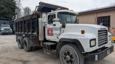 Dump truck 2000 Mack RD690S in-service showing front grille, cab, and dump bed with side panels and chained tailgate.