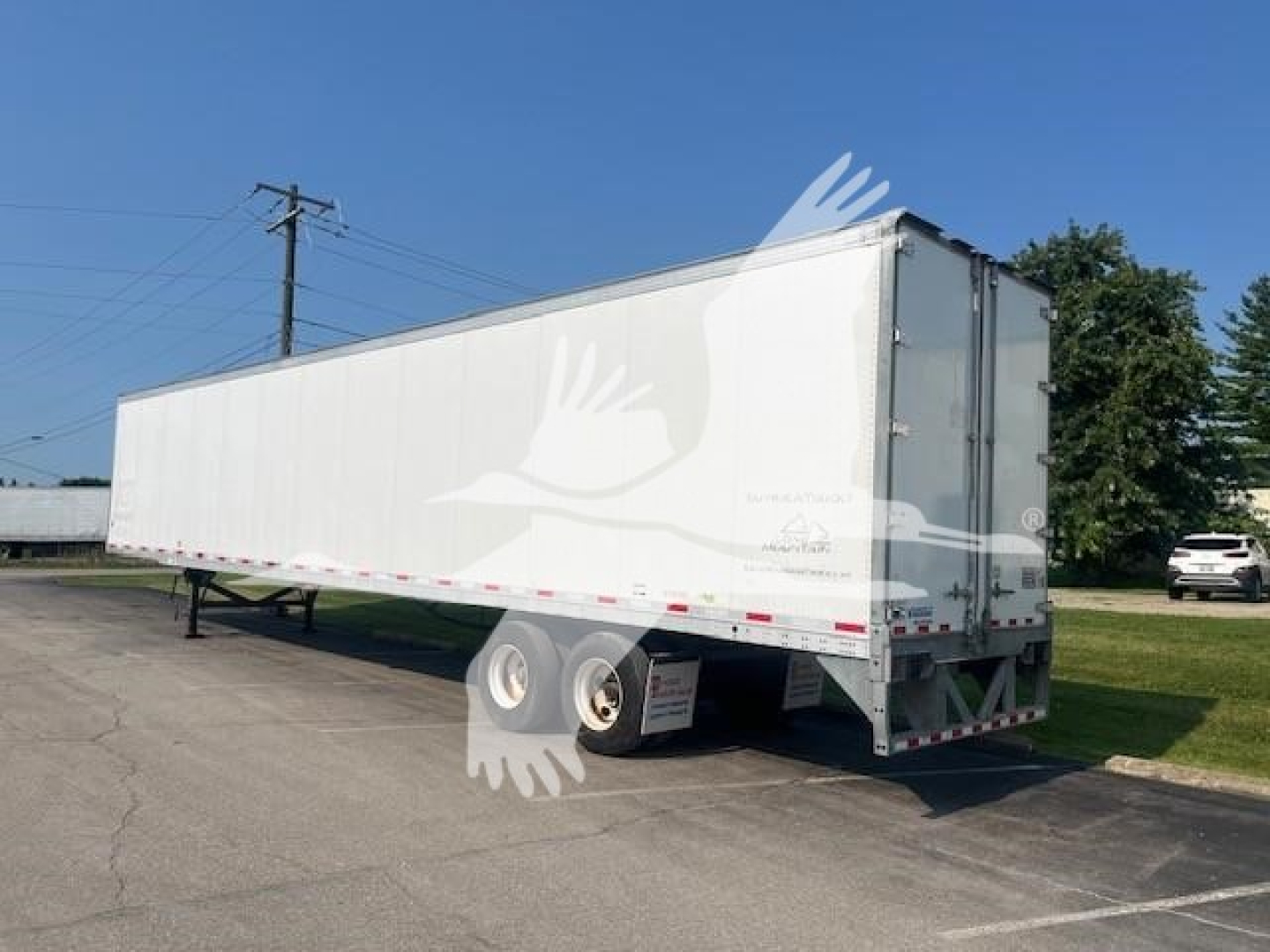 Trailer side view showing Vanguard Maxcube semi-trailer with white exterior and dual rear wheels.