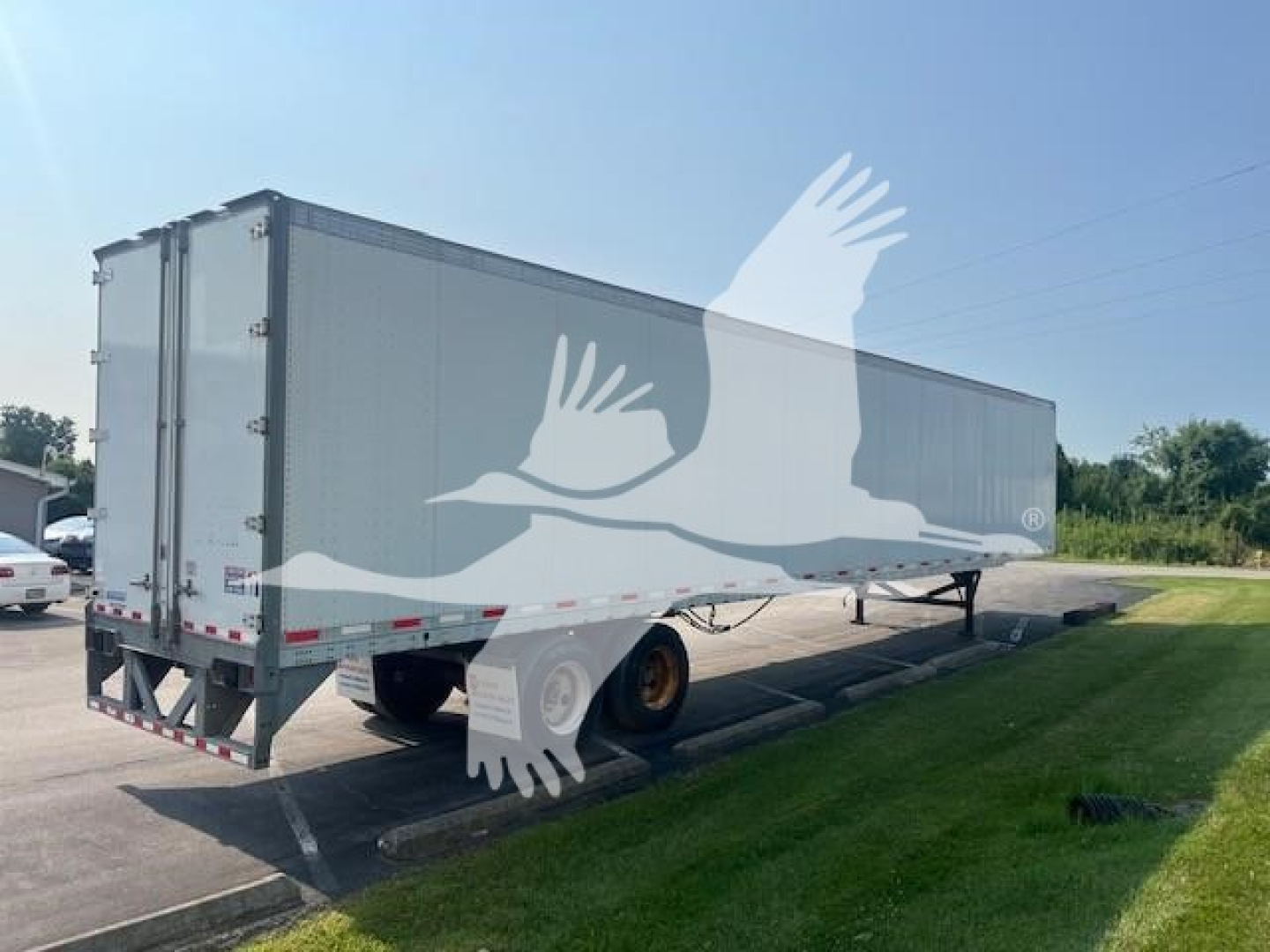 Trailer side view showing a Vanguard Maxcube trailer with rear doors and dual tires undercarriage