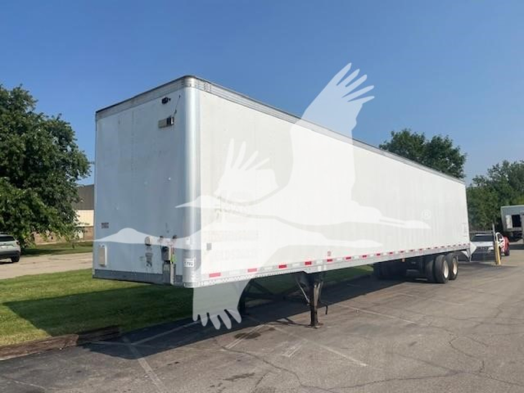 Trailer body of 2017 Vanguard Maxcube semi-trailer showing plain white exterior, dual rear wheels, and support legs in front; side view with clear undercarriage and reflective safety tape.