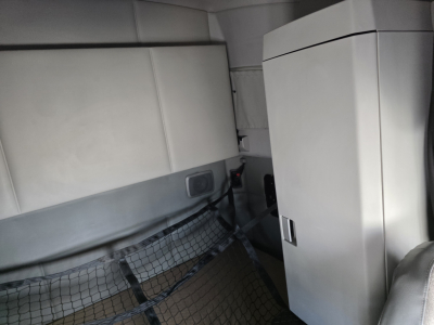 Interior cabin view of a Kenworth T680 showing storage cabinet and partition wall; no visible labels or fuel markings.