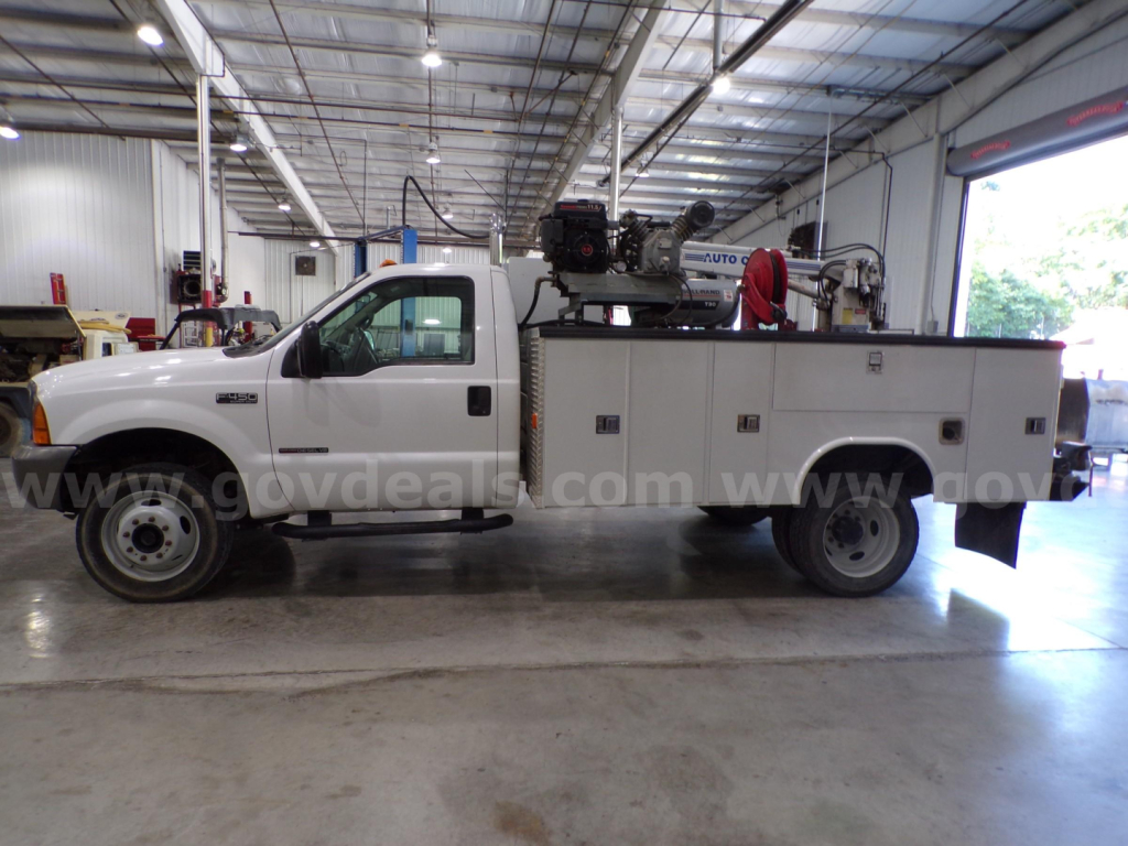 Ford F-450 utility/service truck in a warehouse, long bed with service body and equipment on top, VIN 1FDXF47F7YEC57178