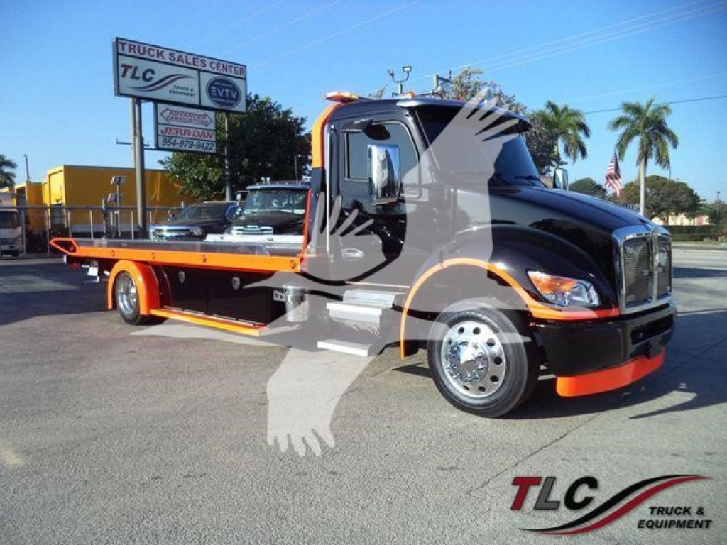 Kenworth T280 rollback tow truck in black and orange livery, side view showing flatbed with chrome wheels.