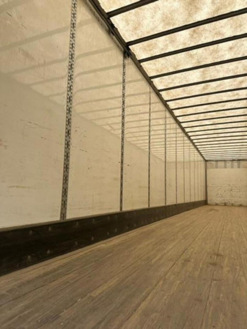 Interior of a 2016 Wabash van trailer with wooden floor, white side walls, and vertical load rails; no visible product text.