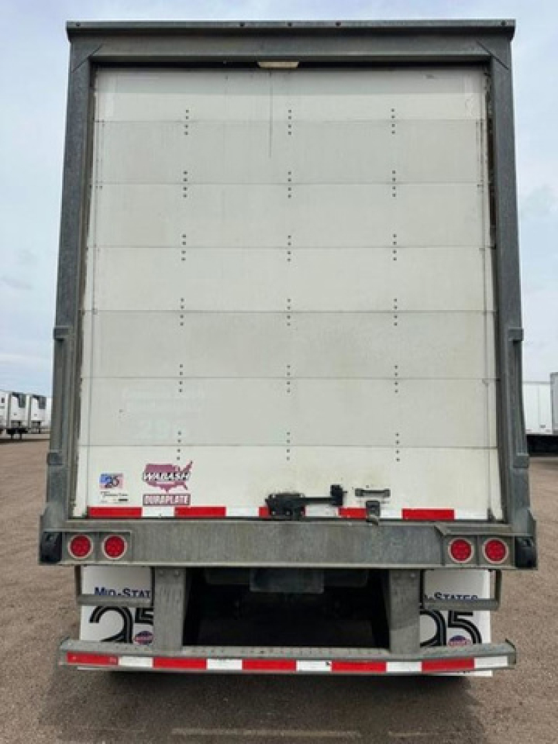 Trailer rear view showing back doors of a 2016 Wabash van trailer with stock U90904, VIN 1JJV532D9GL908634, two rear lights, bumper, and registration decals