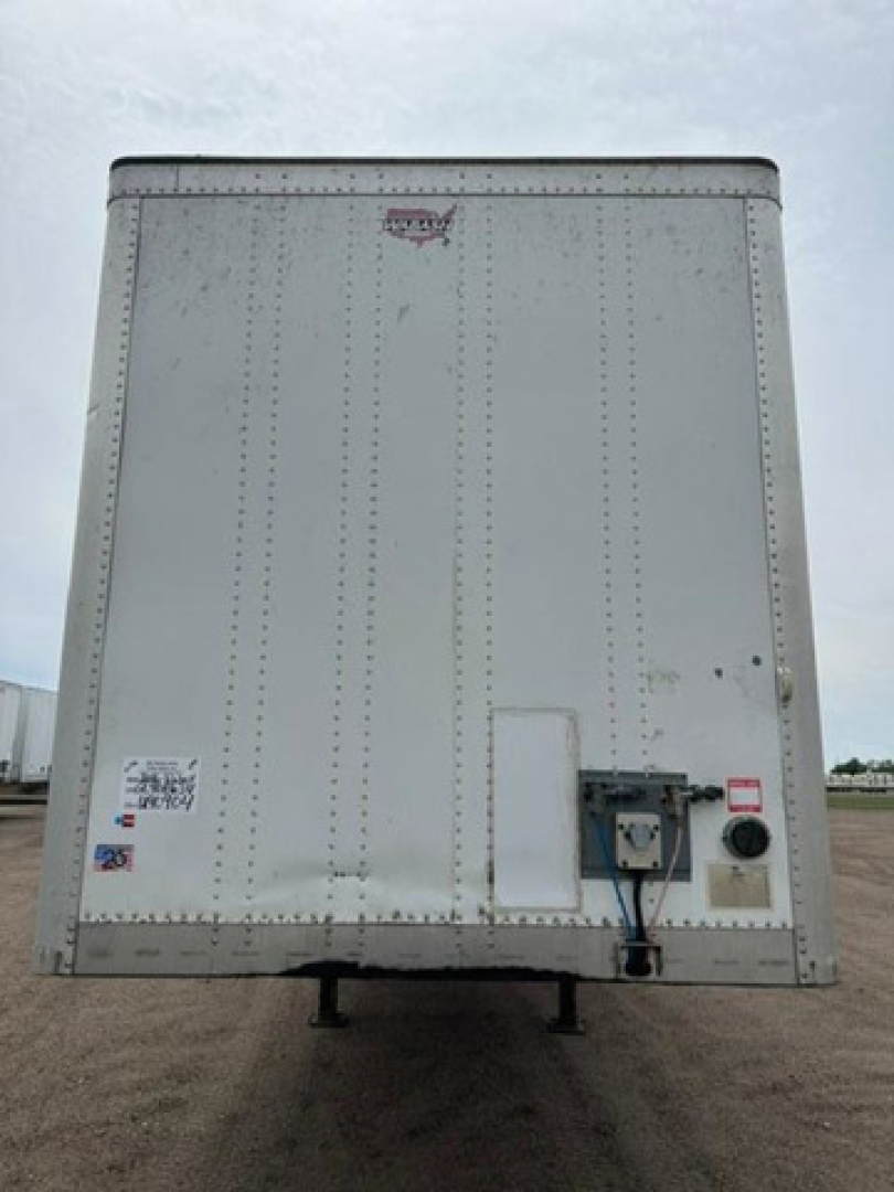 Rear view of a 2016 Wabash van trailer showing riveted aluminum panels, rear door hardware, and utility box with cables.