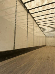Interior of a 2016 Wabash van trailer with wooden floor, white side walls, and vertical load rails; no visible product text.