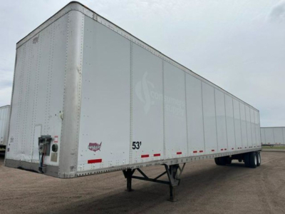 Trailer side view showing a 53' white Wabash van trailer with landing gear and rear door hardware visible.
