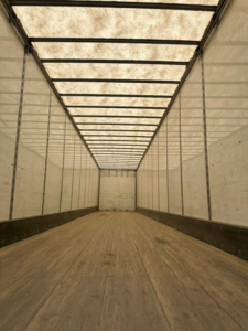 Trailer interior showing empty Wabash van trailer cargo area with wooden floor and ribbed metal walls and ceiling.