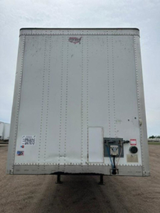 Rear view of a 2016 Wabash van trailer showing riveted aluminum panels, rear door hardware, and utility box with cables.