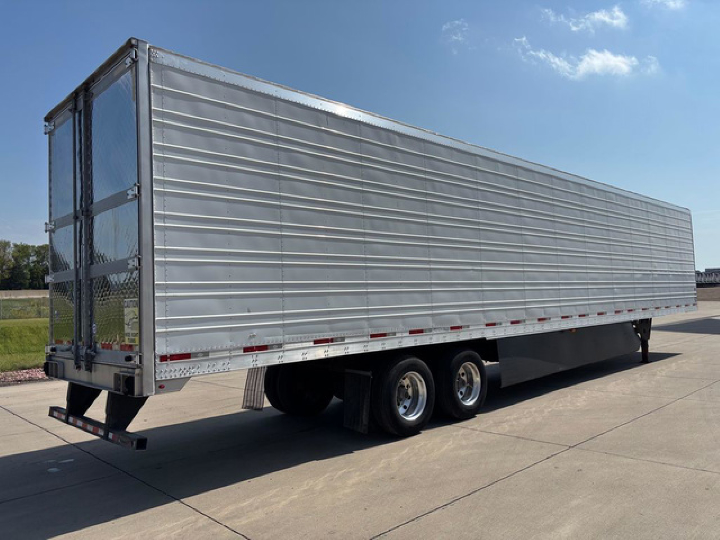 Trailer side view of a 2019 utility refrigerated trailer with metal panel siding, tandem axles, and rear doors.