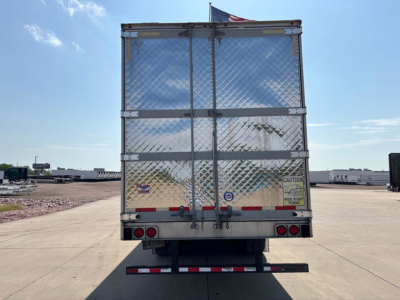 Rear view of a 2019 Utility reefer trailer with diamond plate doors, rear bumper, and taillights. Caution label and reflective strips on doors.