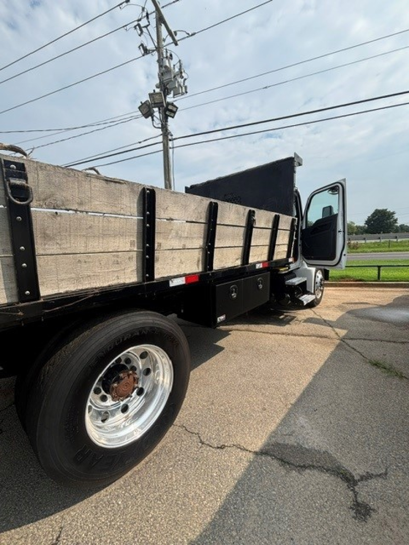 Kenworth T280 cab and chassis side view showing flatbed bed sides and wheel with tire.