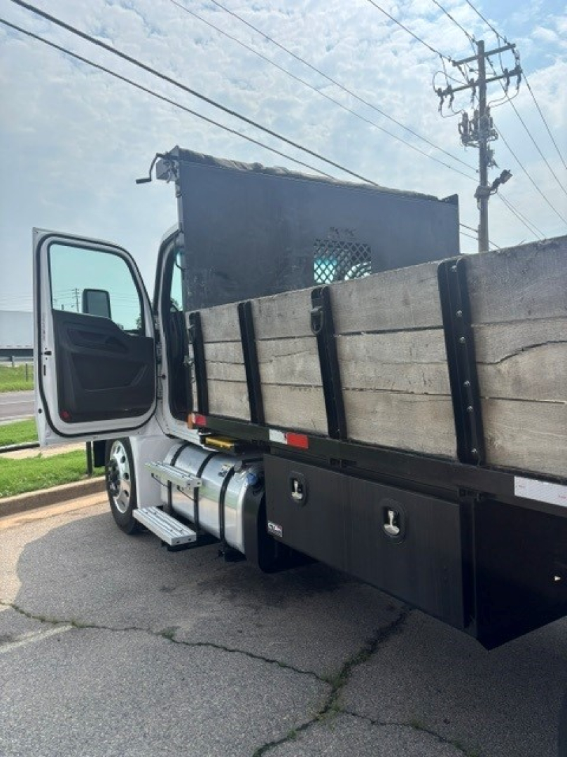 Kenworth T280 cab and chassis side view showing passenger door open, flatbed/sides with metal panels, fuel tank, and step access.