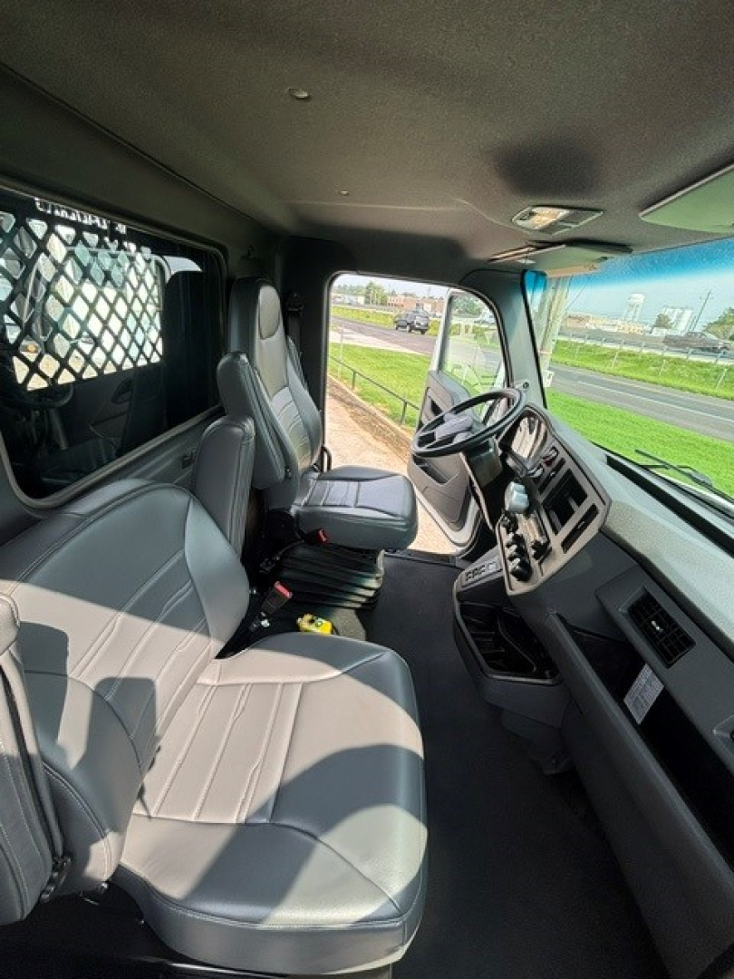 Cab and chassis interior showing driver and passenger seats with steering wheel and dashboard of a Kenworth truck.