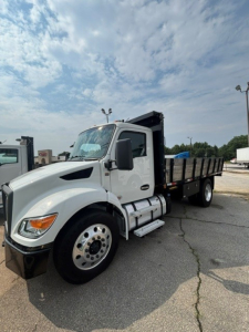 Kenworth T280 cab and chassis truck in a parking lot, front-left view, white with black chassis and dump bed.