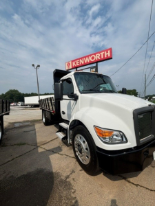 Kenworth T280 cab and chassis truck in white with Kenworth sign in background, front-right view.