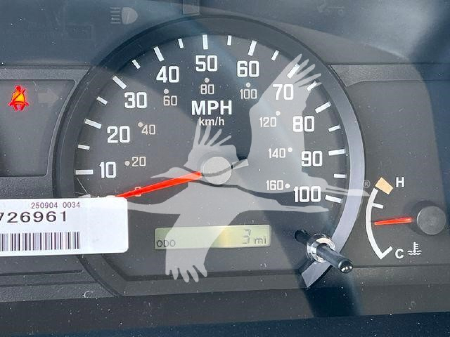 Isuzu NRR rollback truck dashboard showing speedometer (0-100 mph), odometer near 3 miles, temperature gauge, warning indicators, and serial sticker.