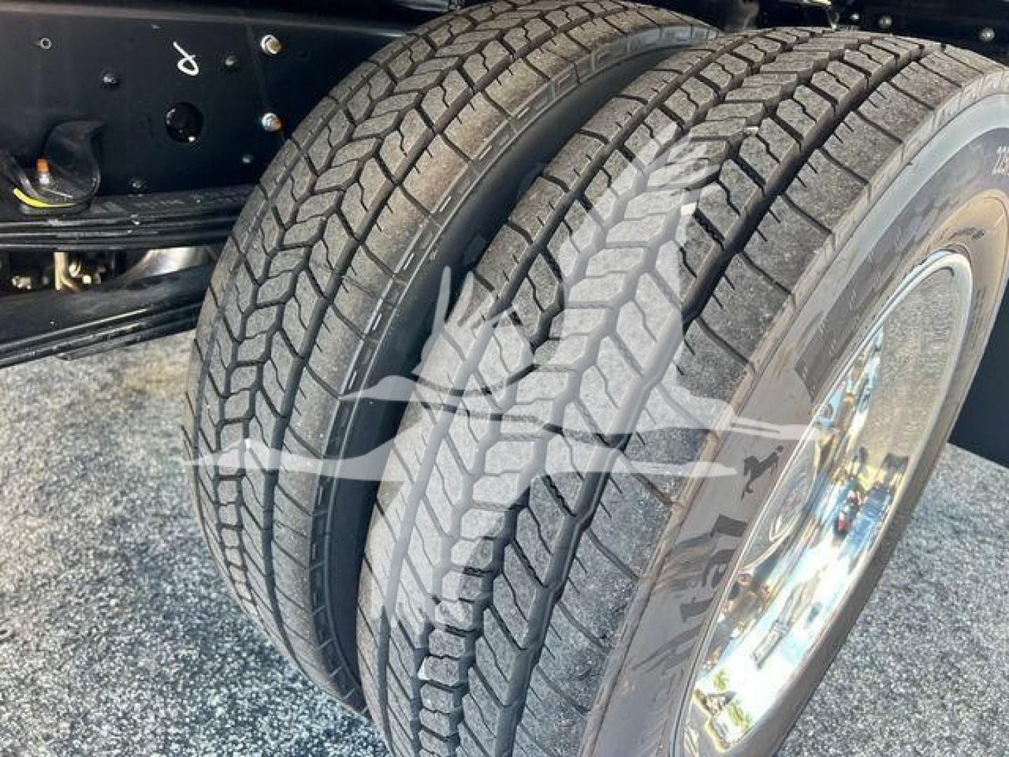 Isuzu NPRR truck dual rear wheels showing tires and suspension with chrome rims.