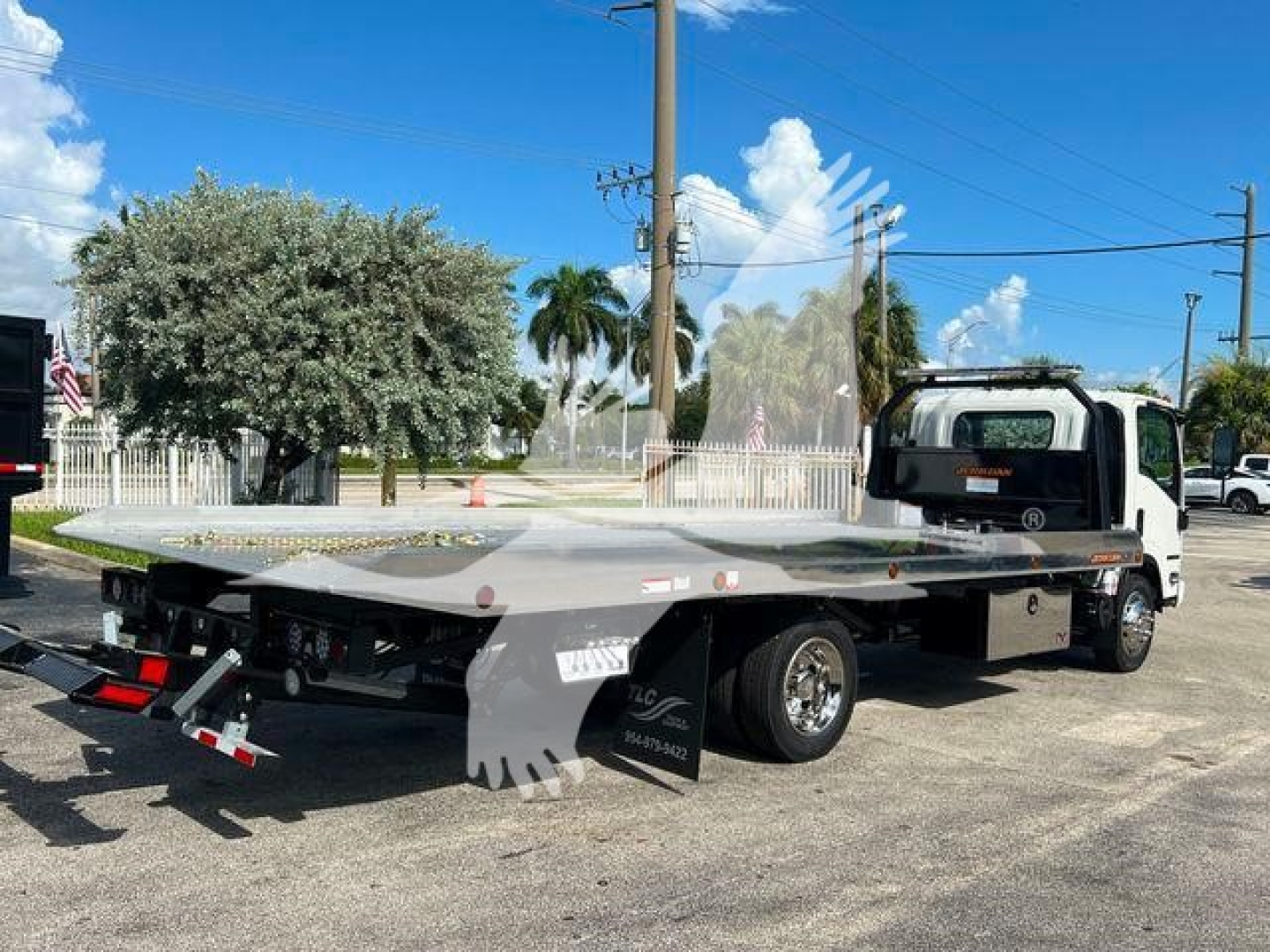 Isuzu NPRR rollback tow truck flatbed with low-angle view showing platform and rear ramps.