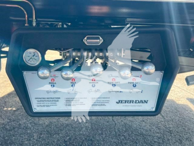Isuzu NPR/RR control panel showing manifold with gauges and switches labeled Jerr-Dan tow equipment, operating instructions visible.