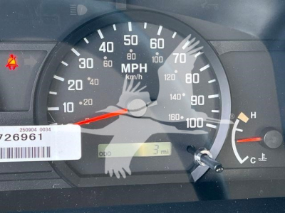 Isuzu NRR rollback truck dashboard showing speedometer (0-100 mph), odometer near 3 miles, temperature gauge, warning indicators, and serial sticker.