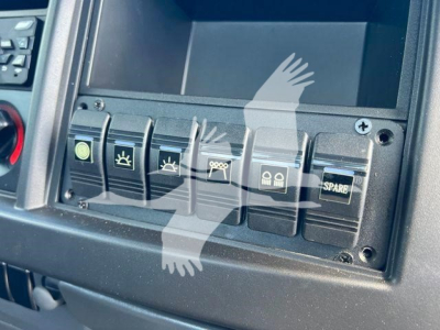 Isuzu NPRR dashboard switches with multiple icons and blank display screen in view showing control panel and buttons.
