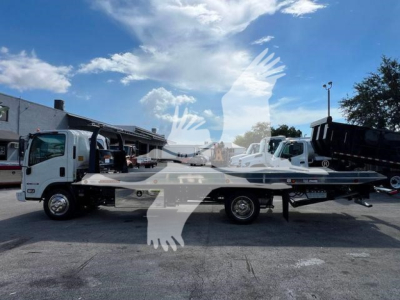 Isuzu NPRR rollback truck in a lot, light gray flatbed with towing equipment.