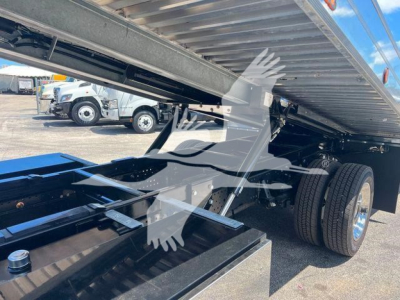 Isuzu NRR rollback truck undercarriage showing dual rear wheels and raised flatbed with structural framing and hydraulic components.