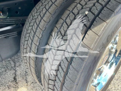 Isuzu NPRR rollback truck wheel and tire tread close-up showing tire pattern and chrome wheel.