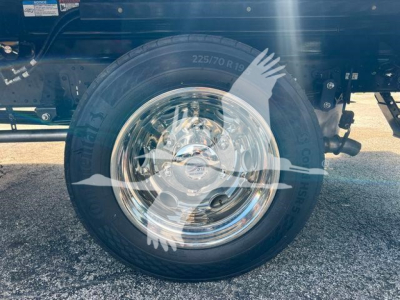 Isuzu NPR/NRR truck wheel with 225/70R19.5 tire showing polished chrome hubcap.