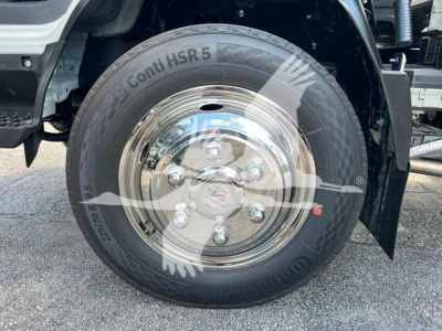 Truck wheel and tire on Isuzu NR R rollback showing Conti HSR 5 tire and polished steel rim with lug nuts.