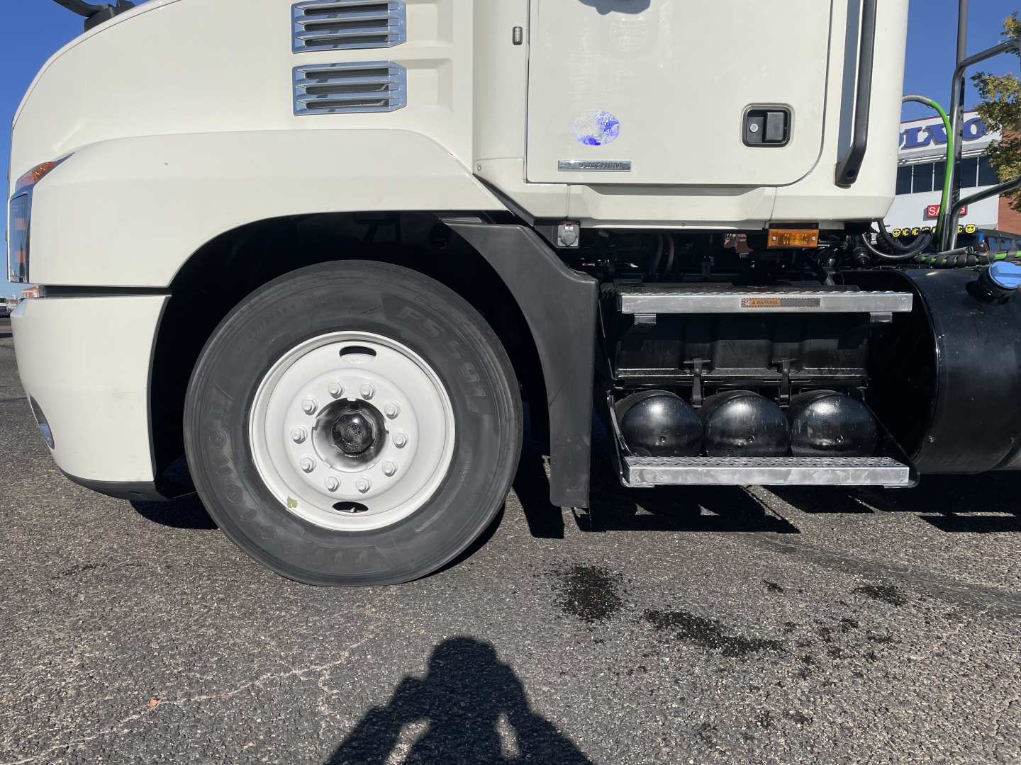Mack AN64T daytime cab truck showing front wheel well and side fuel/air tanks.