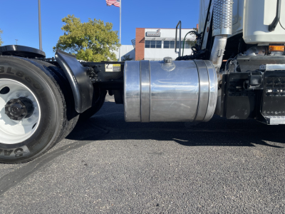Truck engine bay side showing polished cylindrical aluminum fuel tank/air reservoir and chassis with wheel and front axle visible.