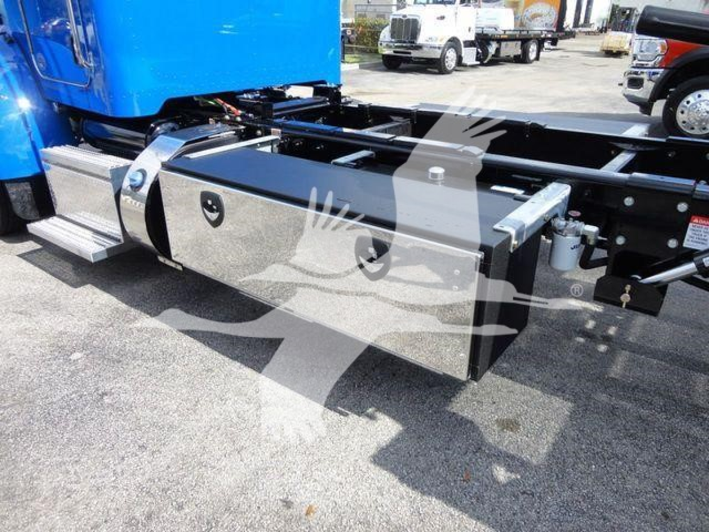 Peterbilt 337 frame and toolbox mounted under truck with chrome box and blue cab visible.