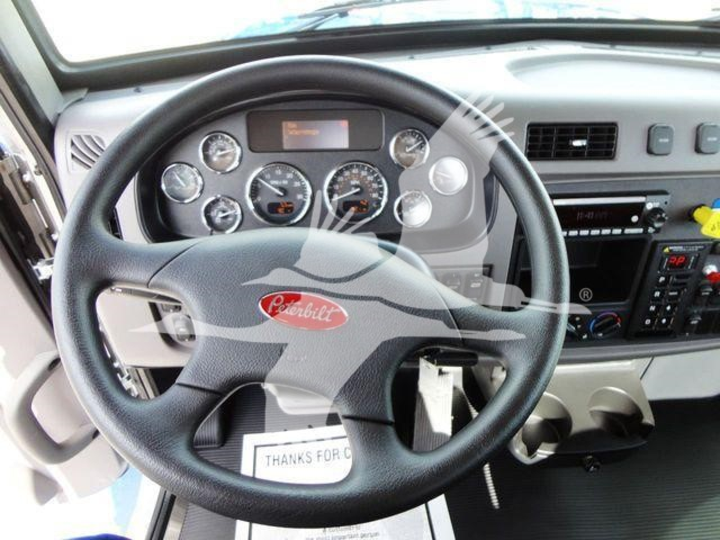 Peterbilt 337 interior steering wheel and dashboard showing gauges, controls, and center console.