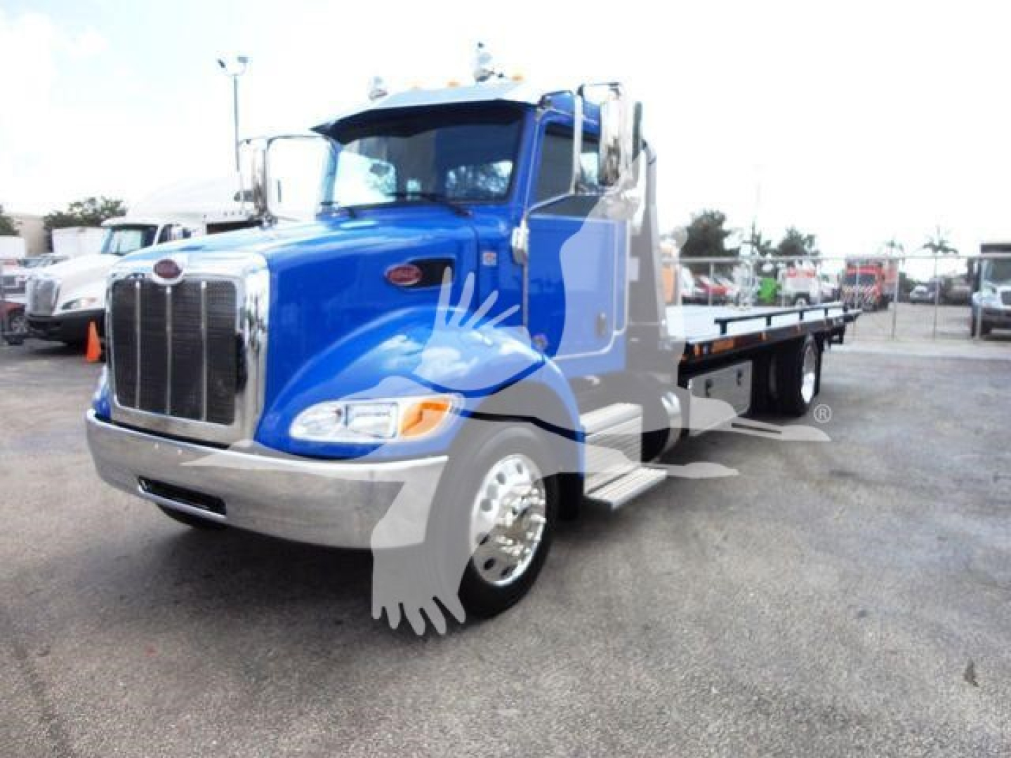 Peterbilt 337 rollback truck blue cab and flatbed showing front grille and headlights