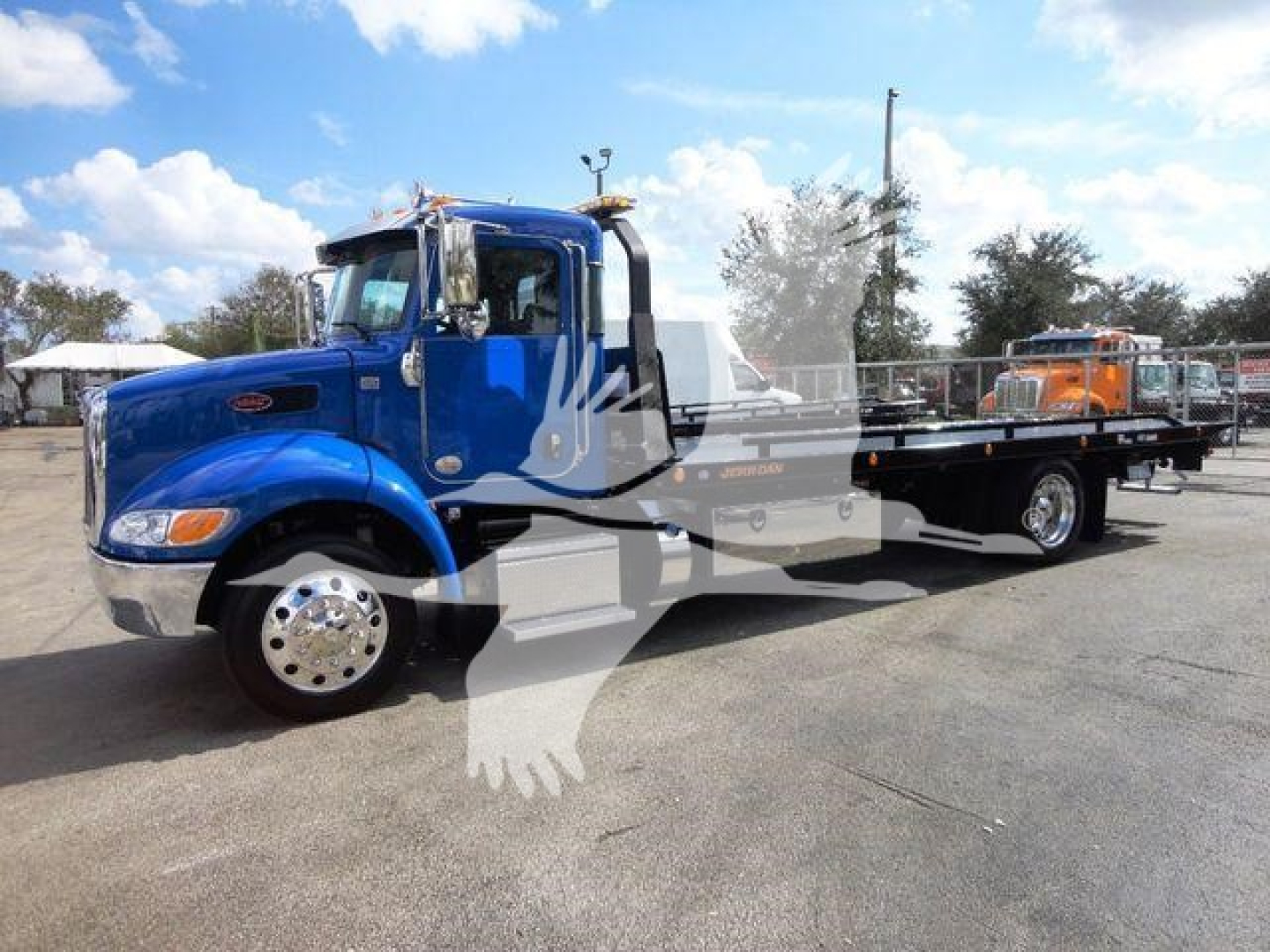Blue Peterbilt 337 rollback tow truck side view with long flatbed.