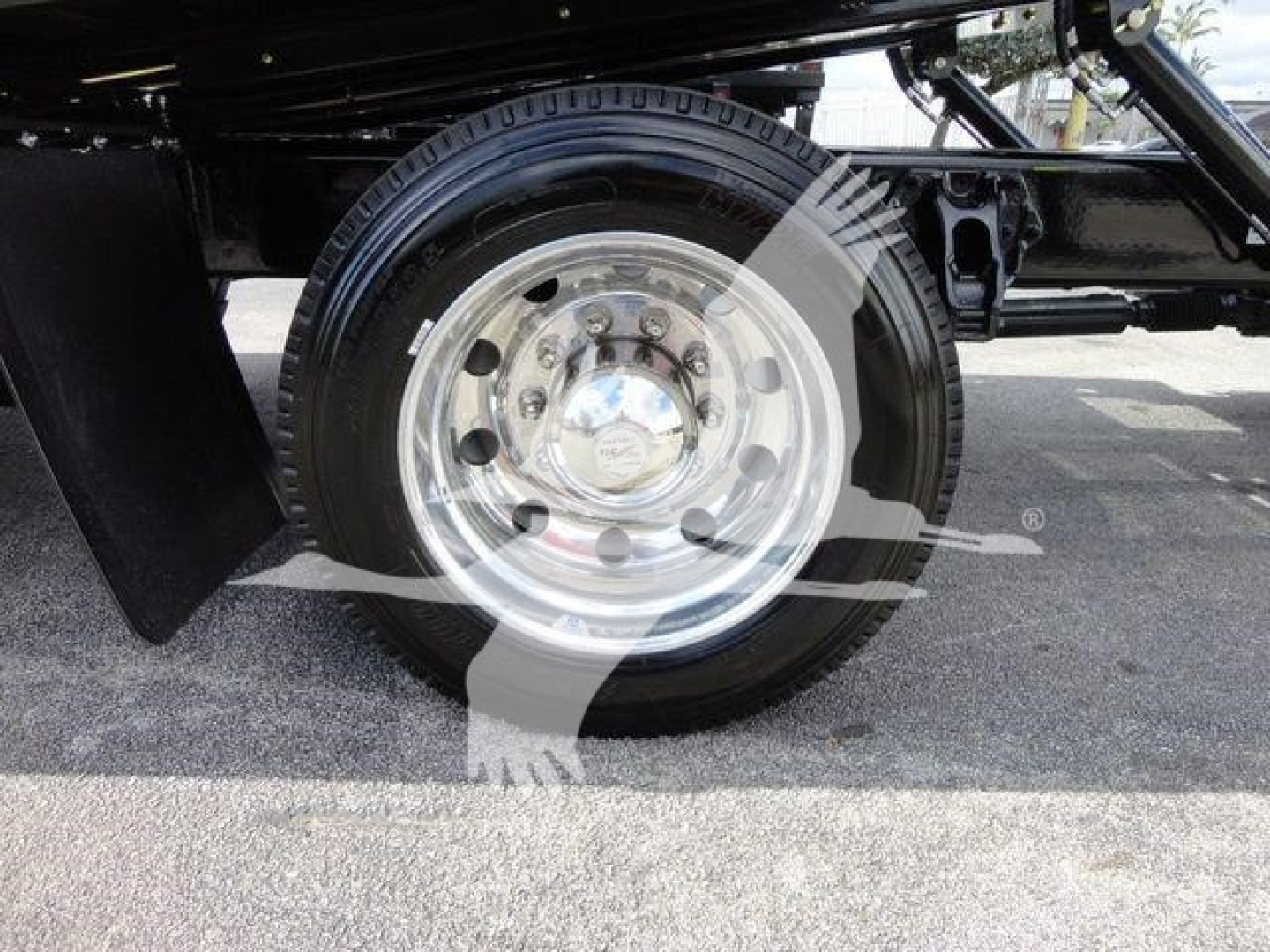 Peterbilt 337 rollback truck wheel and fender view with polished steel rim and black chassis.