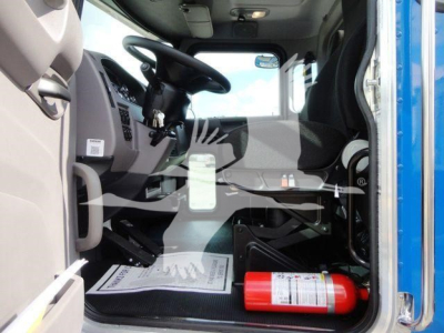 Truck cab interior view of a 2022 Peterbilt 337 Rollback with driver seat, steering wheel, dashboard, and a red fire extinguisher visible on the floor.