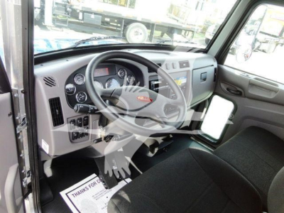 Peterbilt 337 truck cockpit showing steering wheel, dashboard gauges, and driver seat from the open door.