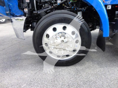 Peterbilt 337 front wheel and chrome hubcap showing tire with visible text.