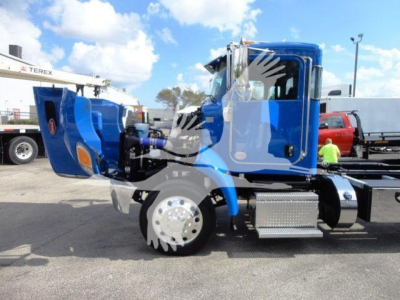 Peterbilt 337 rollback truck side view showing blue cab and chrome fuel tanks.