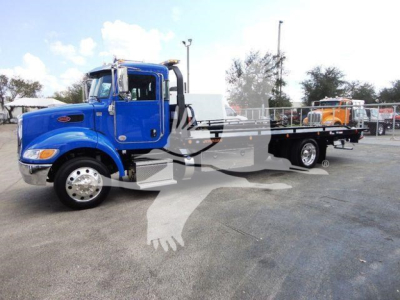 Peterbilt 337 rollback truck in blue, side view showing long flatbed and chrome wheels.