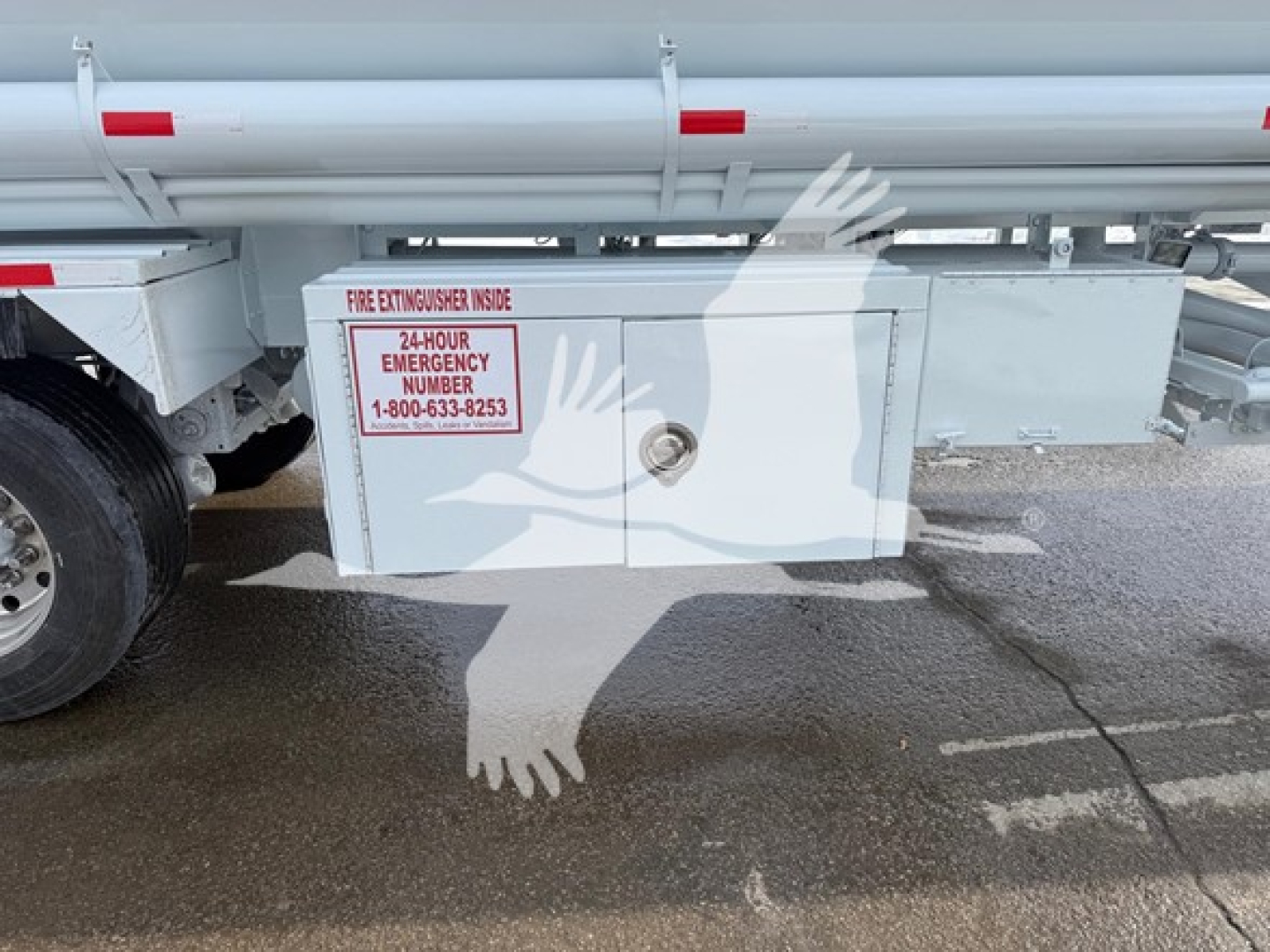Truck trailer side with a mounted metal cabinet labeled Fire Extinguisher Inside, 24-Hour Emergency Number 1-800-633-8253.