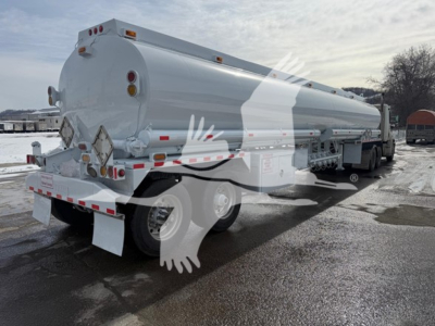 Tank trailer showing rear and side view of a Heil trough bottom Petro Tank with round rear end, rear lights, and dual-axle wheels.