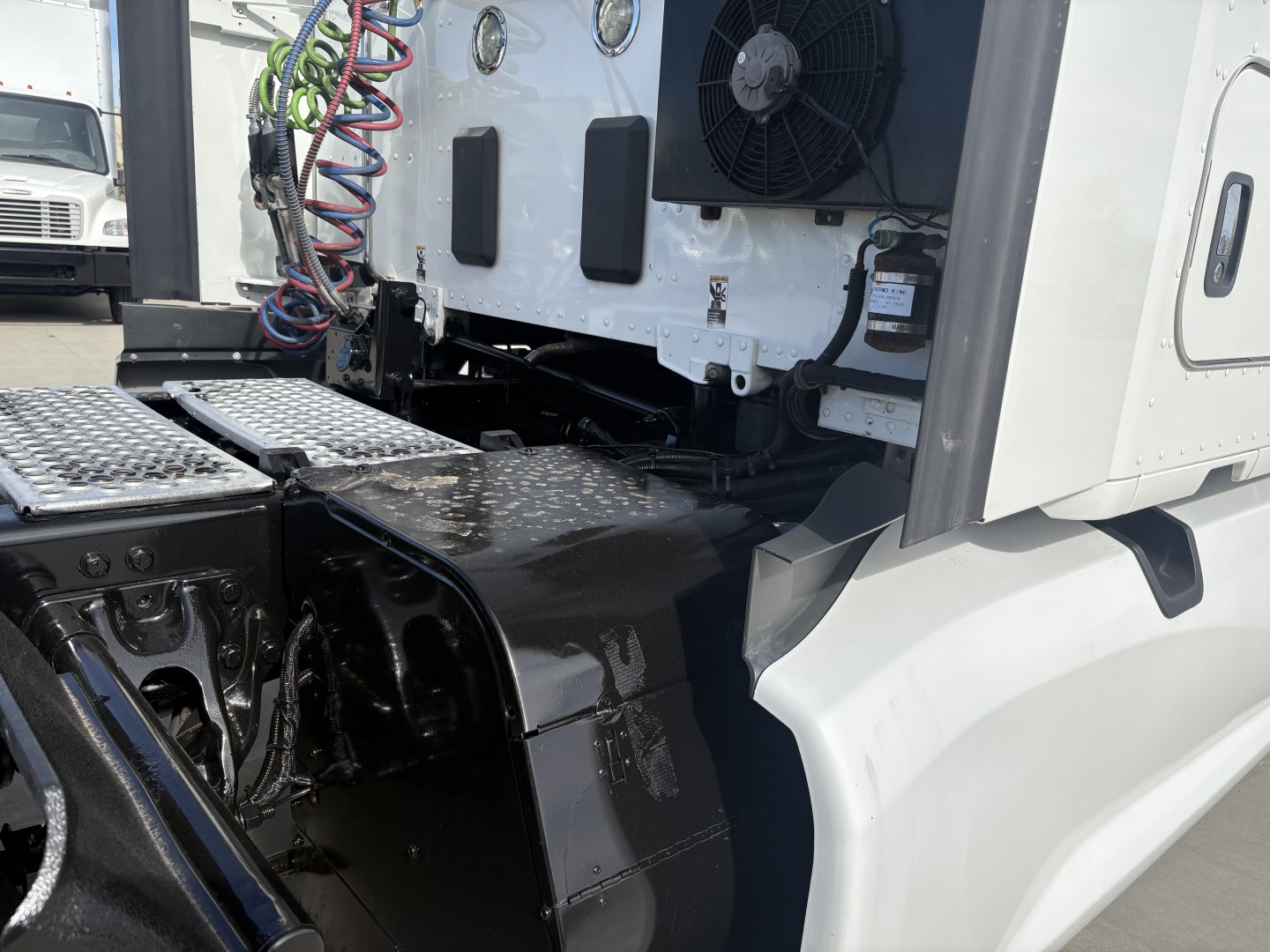Kenworth T680 cab area showing engine bay components and wiring harnesses